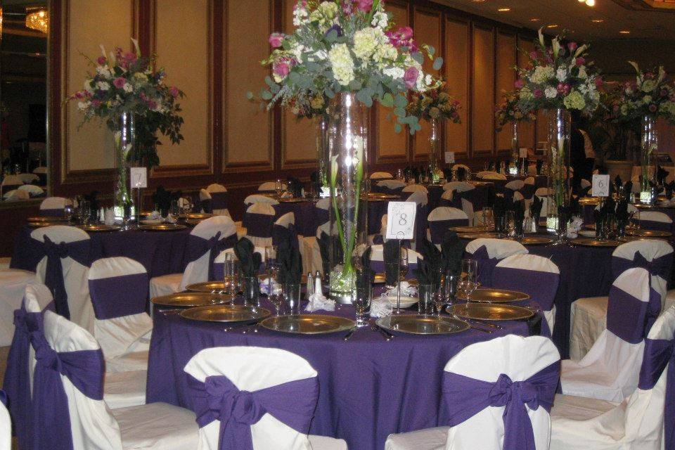 Purple and white centerpieces elegantly match the theme of this wedding.