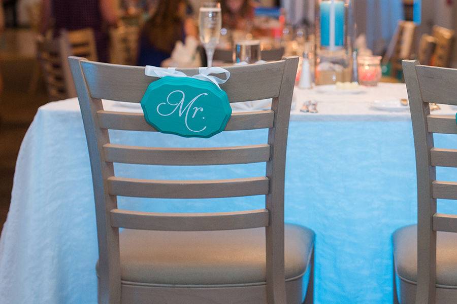 Wavy oval wooden chair signs for a Cape Cod wedding at Sea Crest Beach Hotel in Falmouth, Massachusetts. Photo courtesy of Shoreshotz Weddings.