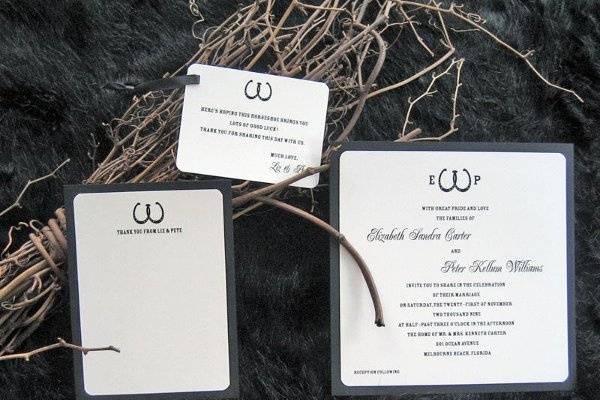 Square black and ivory wedding invitation, flat thank you card, and favor tag with custom double-horseshoe motif.