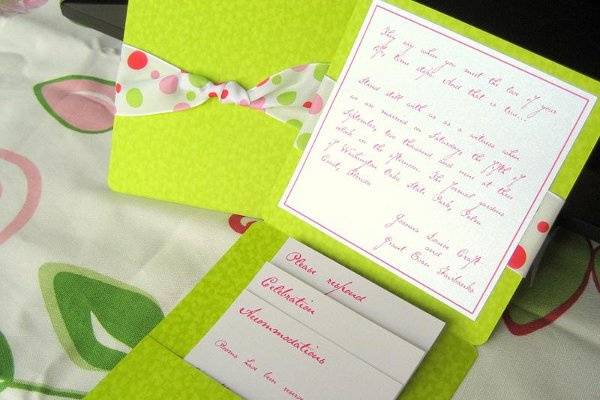 Green apple folding pocket wedding invitation with pink and green dotted ribbon.