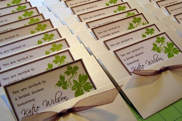 Pocket or pouch invitation adorned with sheer brown ribbon.  Uses green grape leaf design.