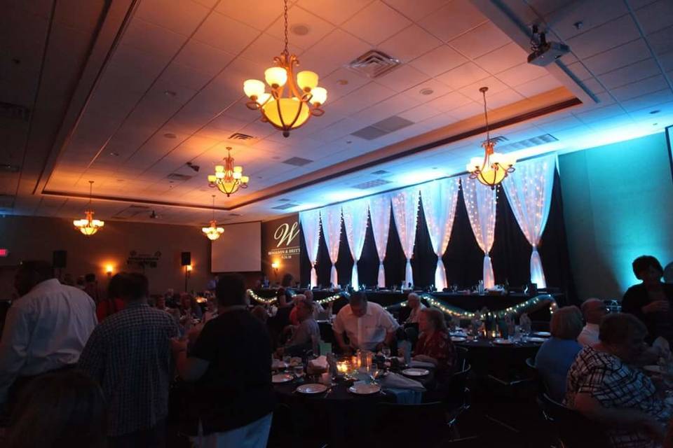 920 Events providing floor to ceiling backdrop for the head table.  Black satin, white chiffon with twinkle lights.