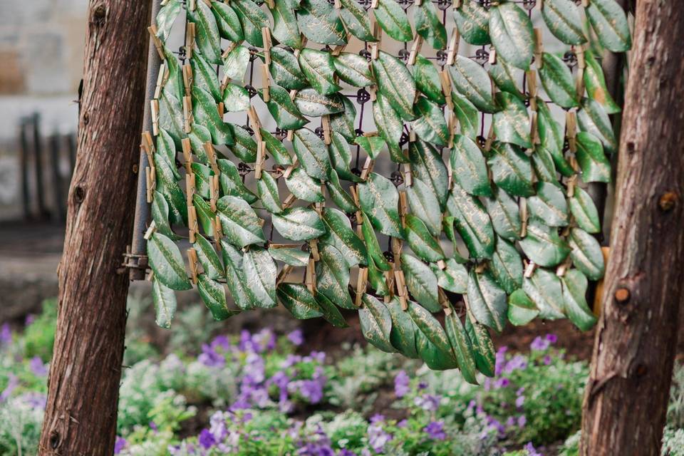 magnolia leaves as escort cards with gold calligraphy on the sentimental gate built into a functional tripod for the wedding day