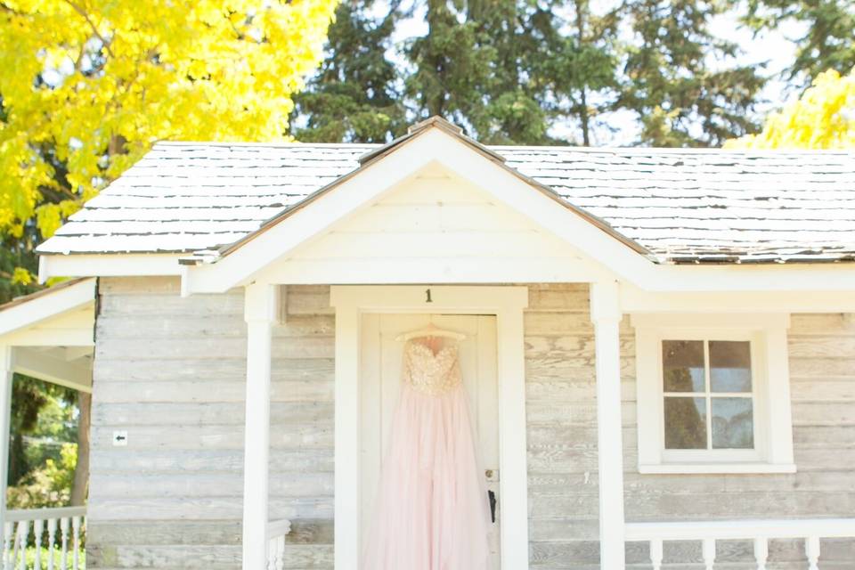 Laura Nichols Photography hangs a bride's dress on our vintage bridal cottage as if to say, 