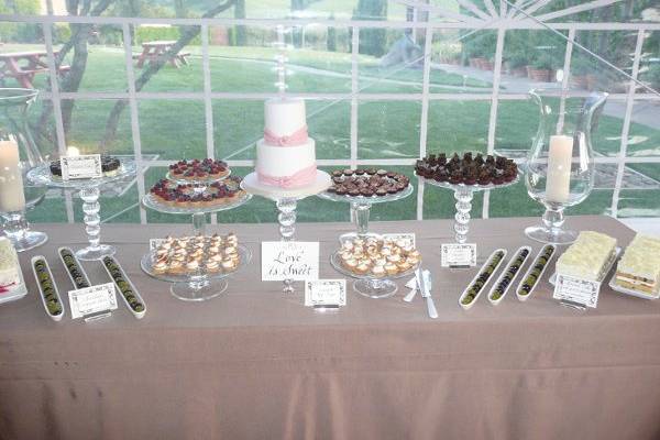 Dessert table with petit fours and a small cutting cake.