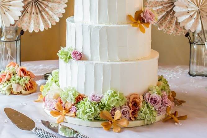 Rustic buttercream finish with a fresh peony accent.