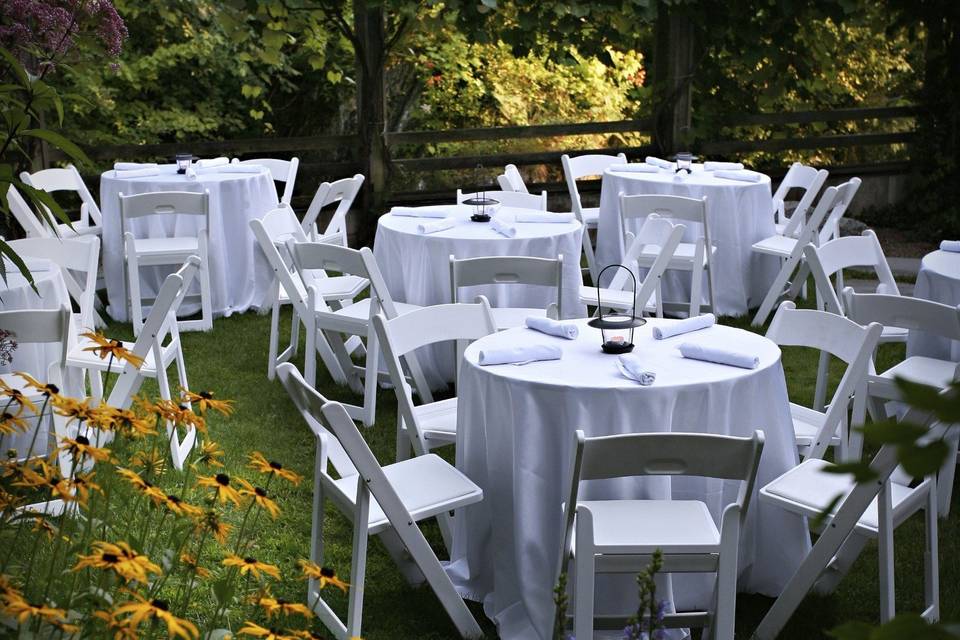 Outdoor dinner seating in our garden, ringed by concord grape arbors and Freeman Brook.