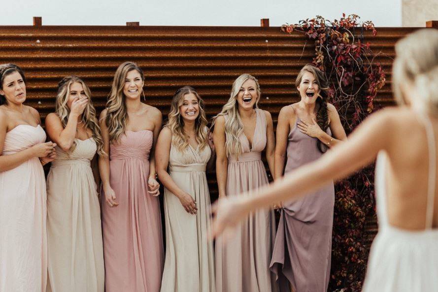 Bridesmaids see their bride in her dress