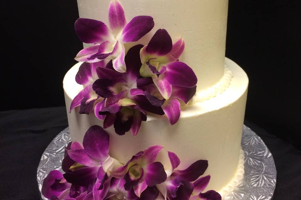 Fresh Orchids adorn this buttercream wedding cake.