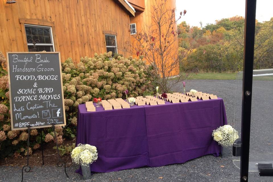 Guest place cards surrounded by bud vases and a chalkboard sign with essential informations for guests. Ceremony flowers were moved to 