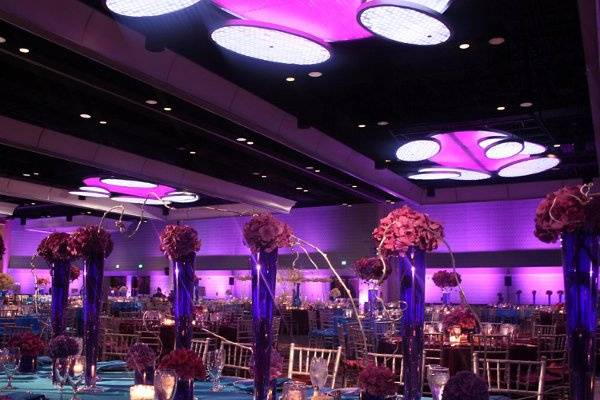 Color washes across ballroom walls in complementary wedding colors.