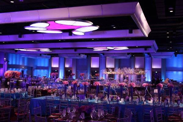 Color washes across ballroom walls in complementary wedding colors.