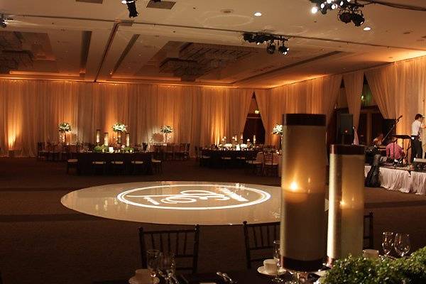 Candlelight colored uplights and pinspots that highlighted unique centerpieces adorned the ballroom draped walls.