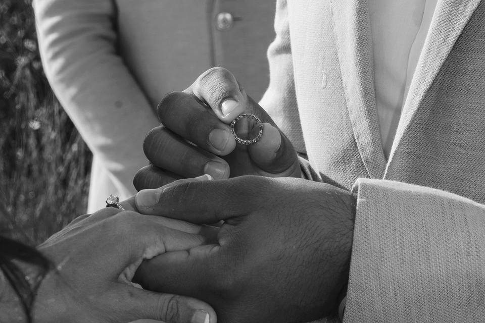 Groom Steadies ls the Brides Hand as he Puts the Ring on Her Finger