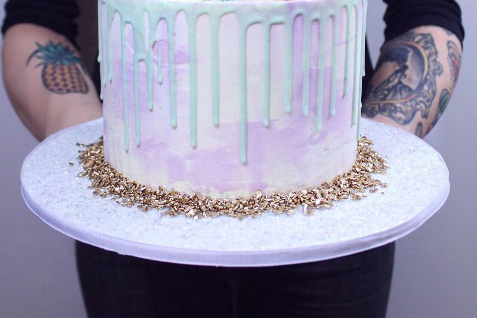 Pastel drip cake with fresh flowers and gold splatter