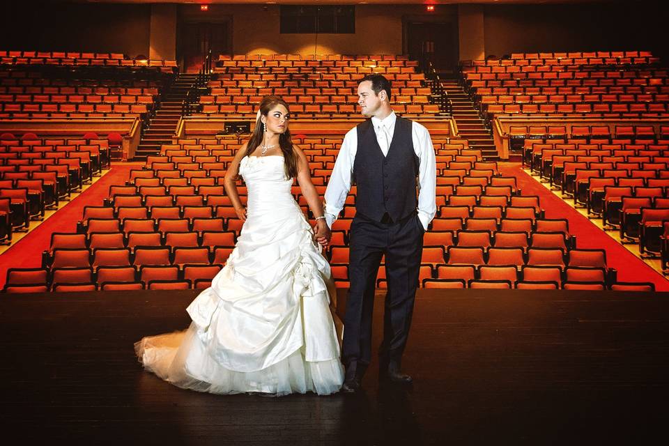 DCP wedding couple on stage alone in large theatre.