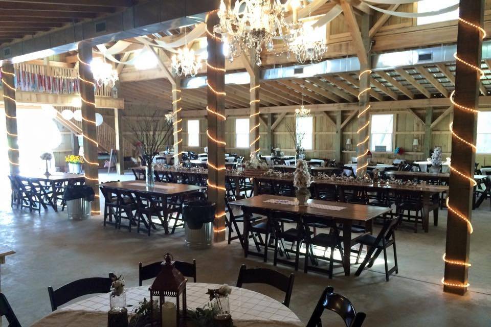 Barn reception enhanced by mahogany garden chairs.