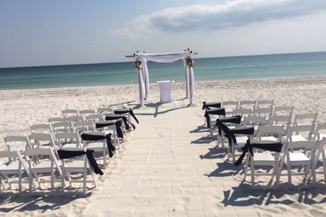 Beautiful Bamboo arbor with ceremony table and white garden chairs.