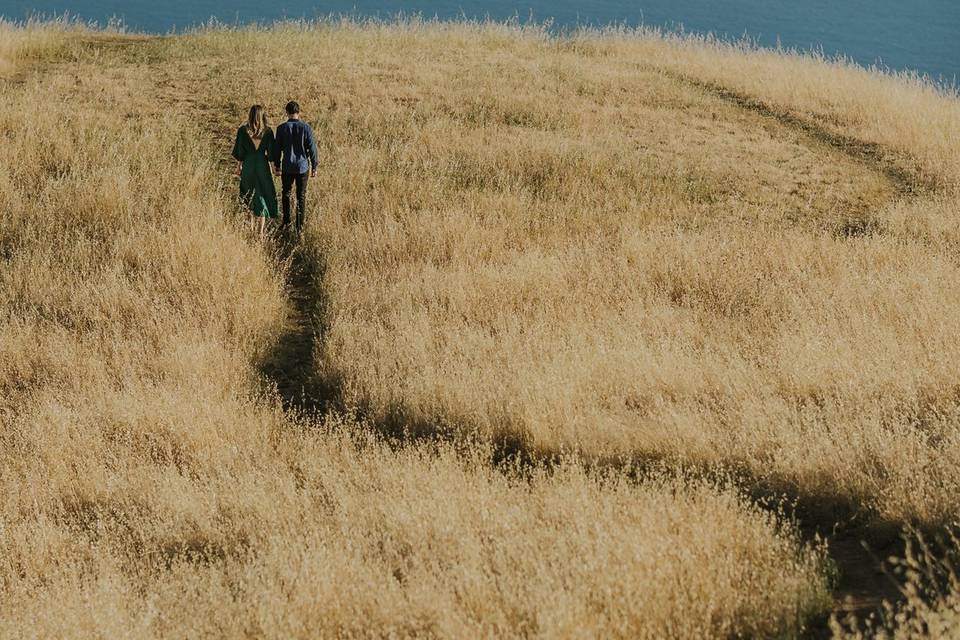 Couple running through field