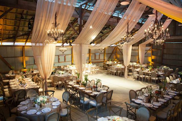 An old rustic barn was converted with chiffon drapery and chandelier lighting