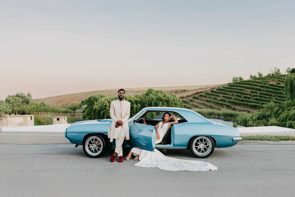 Bride + groom in front of car
