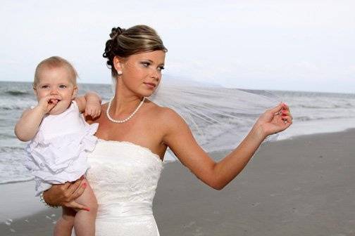 Bride on beach with flower girl