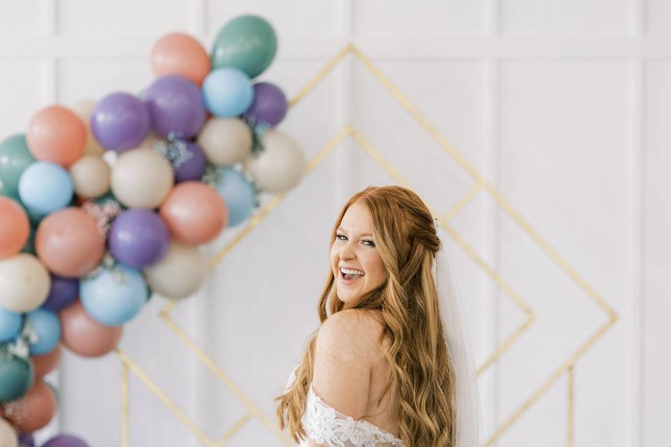 Bride in front of balloon arch