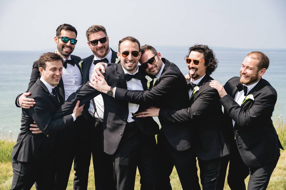 Groomsmen hug the groom