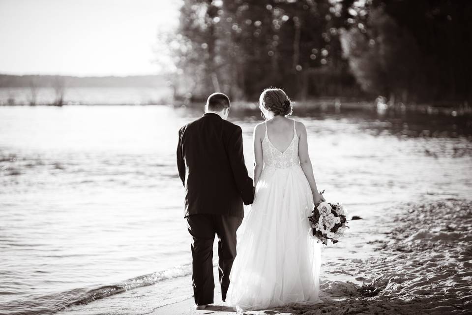 Bride and groom walk the beach