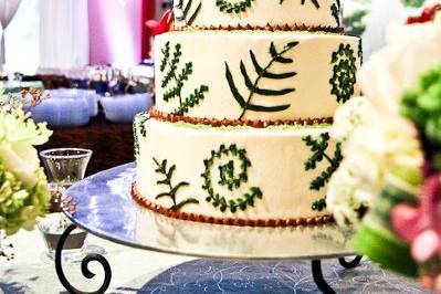 The vegan couple had a friend create the top two tiers of raw cake.  Chef Casey baked the vegan bottom two tiers and topped it off with vegan buttercream icing! Chef Casey put all four tiers together and decorated the cake with a beautiful fern design.Photo by Spots of Time Photography