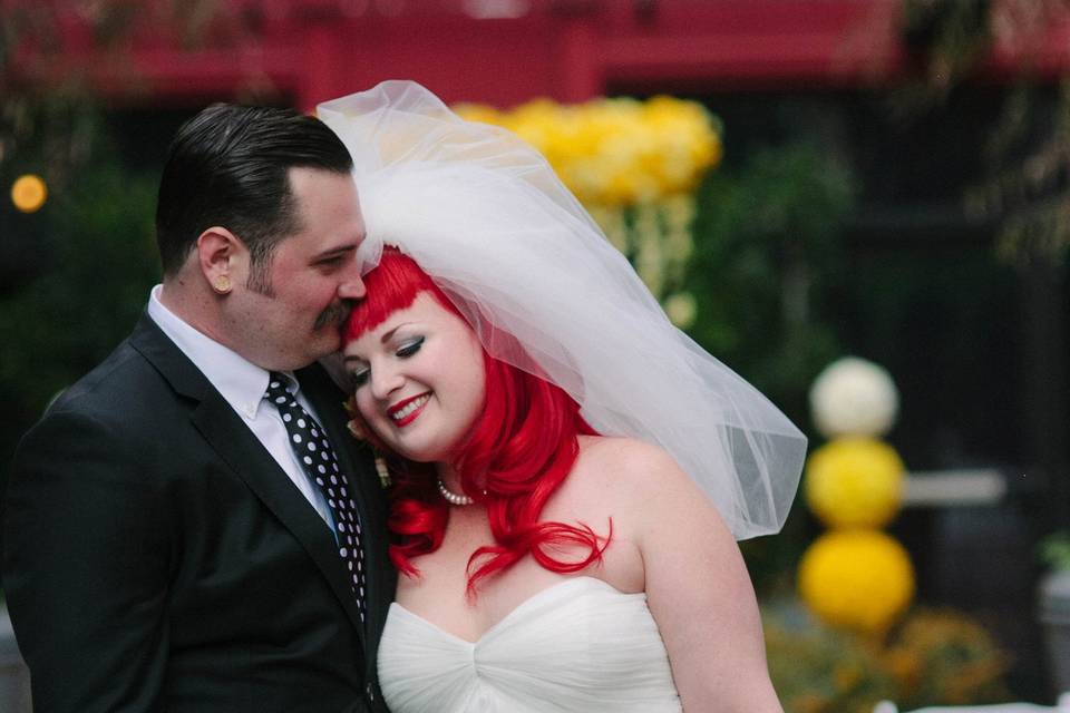 Bridesmaids in polkadots carry bouquets of white with yellow accents.