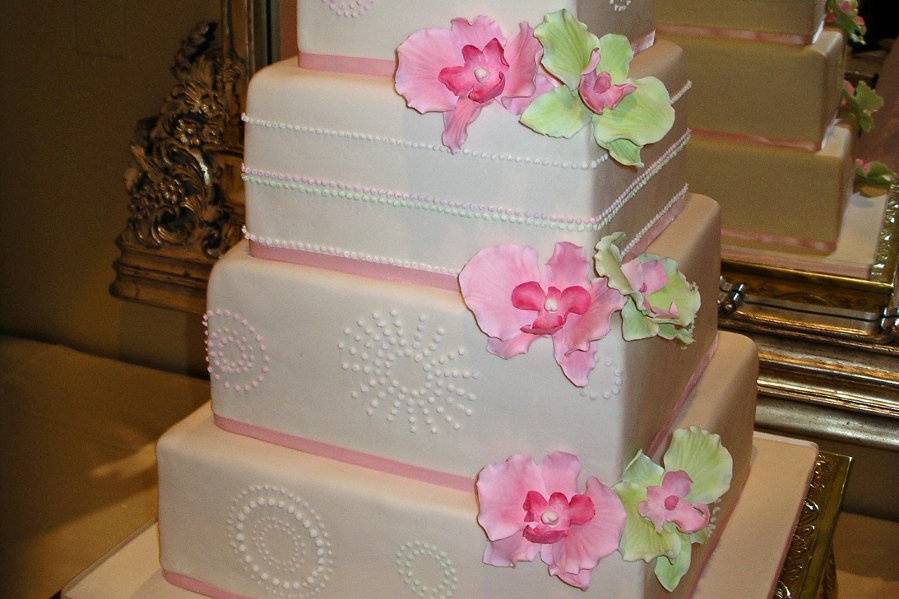 Green and pink orchids, with piped sunbursts, wedding cake