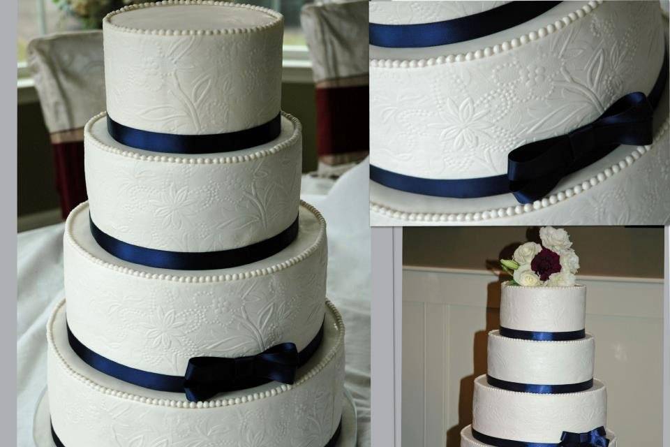 White wedding cake, with embossed pattern on sides of tiers.  Custom make mold from the couple's wedding invitation paper.