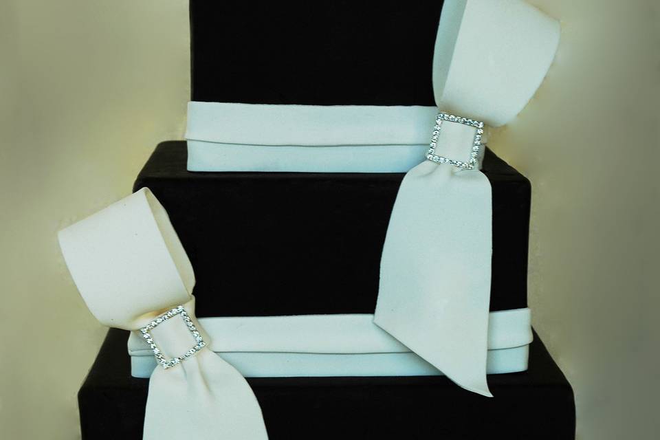 A black and white wedding cake, elegant and formal, with single loop bows.