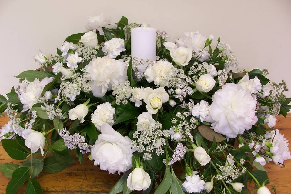 Alter arrangement of white roses, peonies, Queen Ann's Lace and delphinium.