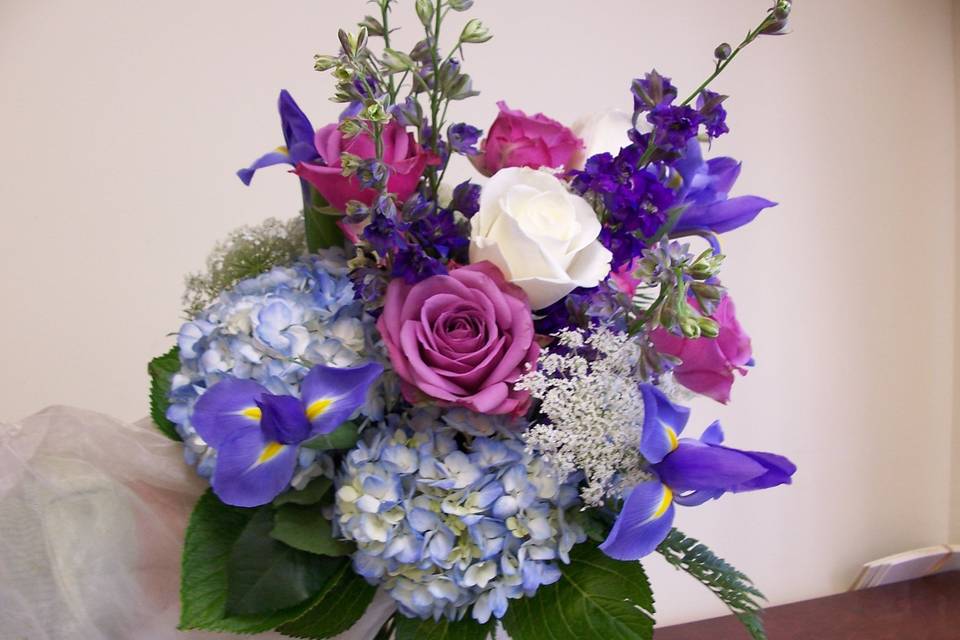 Blue hydrangeas, iris and larkspur with lavender roses decorate the reception.