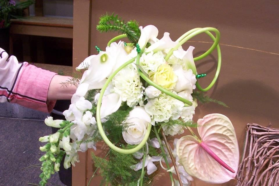 White orchids, roses and antheriums accented with curled calla lilies.