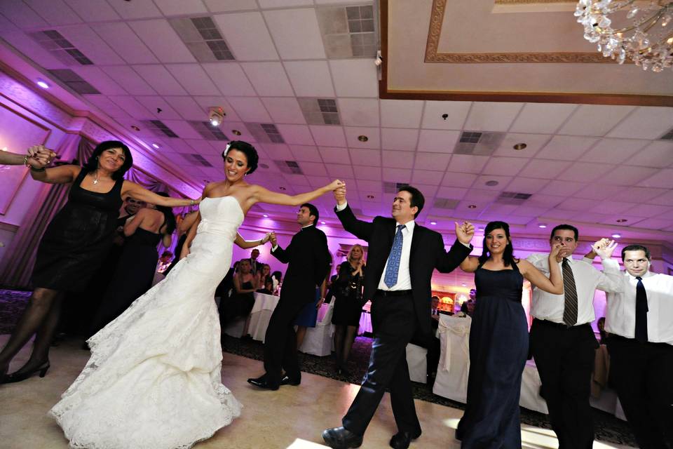 The couple dancing with their bridesmaids and groomsmen