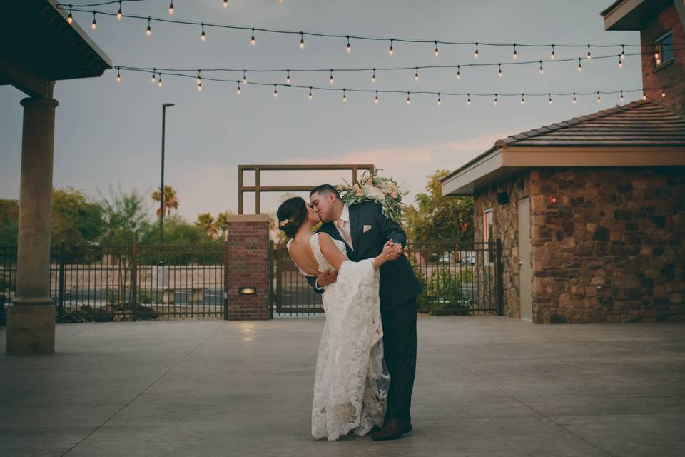 Sharing a kiss beneath the bistro lighting