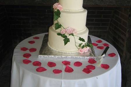 3 tier round buttercream cake with cascading ivy and sugar roses.