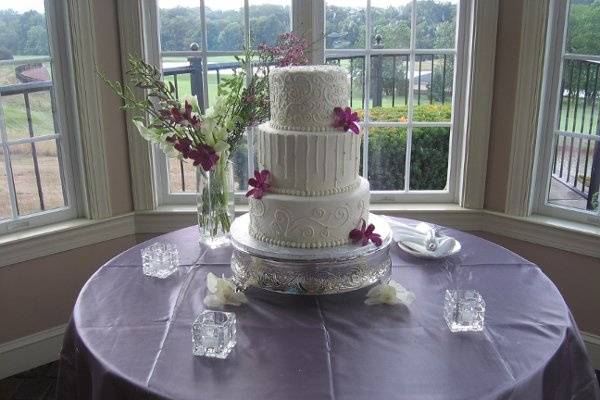 3 tier round buttercream cake with scroll work, icesickles and silver dragees.