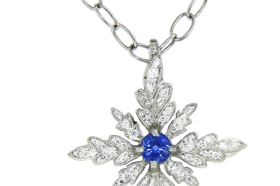 This gorgeous pendant from Cathy Waterman is composed of platinum, a detailed cross featuring oak leaves is set in diamonds, and centered with a faceted blue sapphire with a diamond loop. The diamonds share a carat weight of 0.21cts. Measures 1 1/8