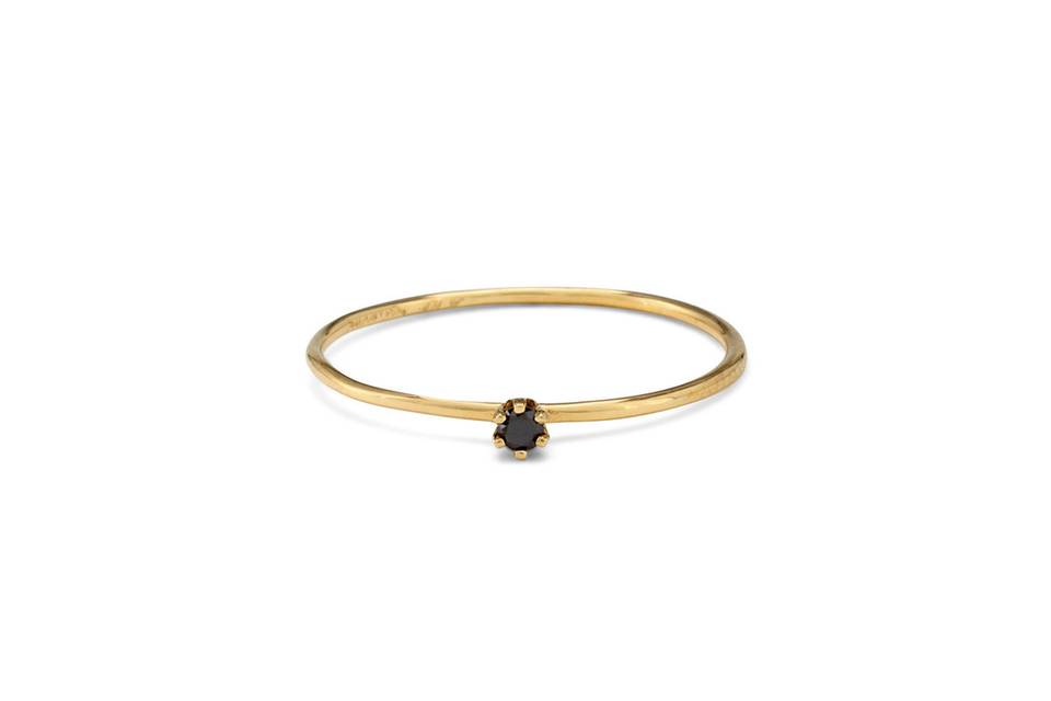 Each ring from designer Satomi Kawakita is handmade with impeccable precision. This thin, simple 18 karat yellow gold band features a tiny prong set black diamond center. It has a lovely matte finish and looks lovely stacked or worn alone.