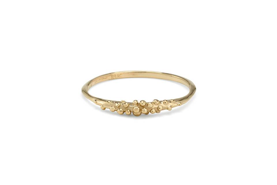 This dainty ring from Satomi Kawakita is detailed by hand in 18 kart yellow gold and features a thin band with beautiful bead clusters in the center. Each bead has a high polished finish against a matte background, and it looks lovely stacked with your other favorites by Satomi.
