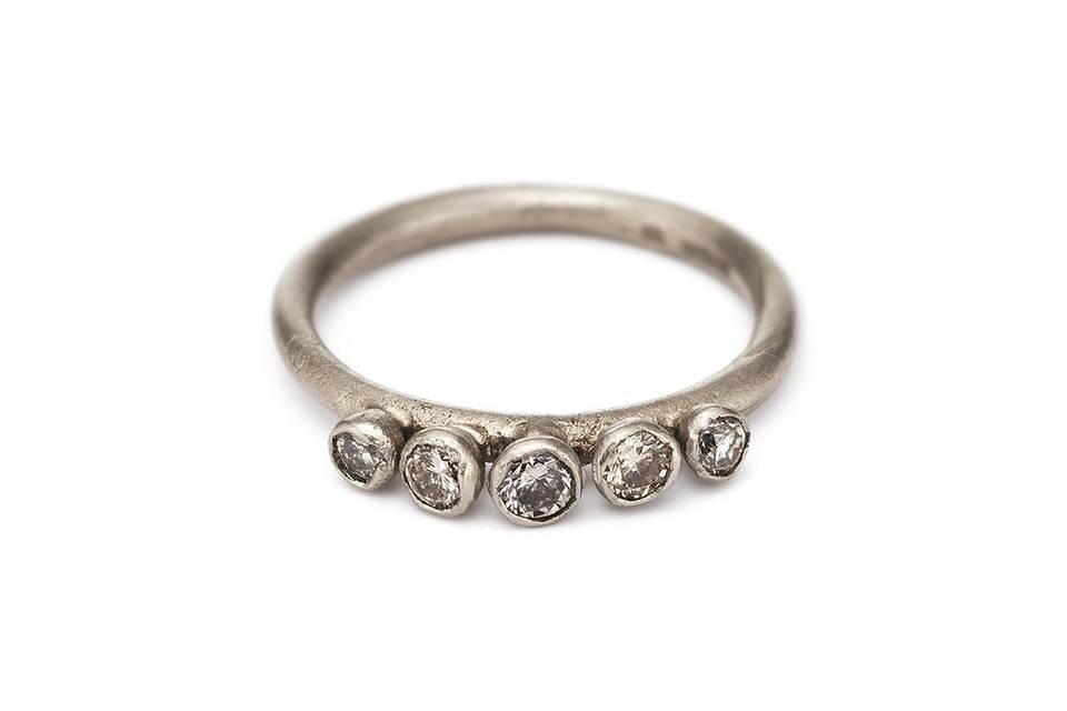 Each diamond in this five-diamond ring from designer Ruth Tomlinson is set individually and slightly elevated, the handcrafted details allowing the light to catch the stones just right. The ring is cast in 18 karat white gold. The perfect capstone to your stack.