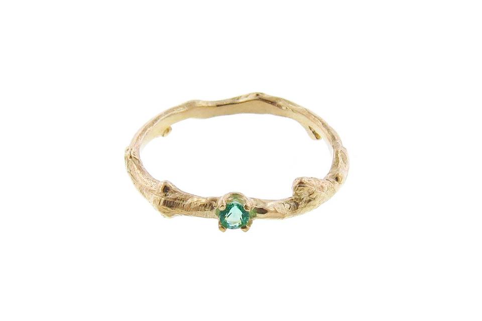 This dainty ring from Yayoi Forest is perfect for stacking! Set in 14 karat yellow gold on a twig band with an emerald in the center. It's a must have.