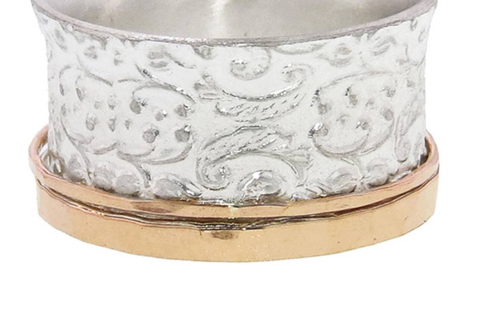 This artisan David Tishbi wide band in recycled sterling silver has a wonderful matte finish with a paisley design and a hammered 14 karat rose gold edge. It stands 1/2