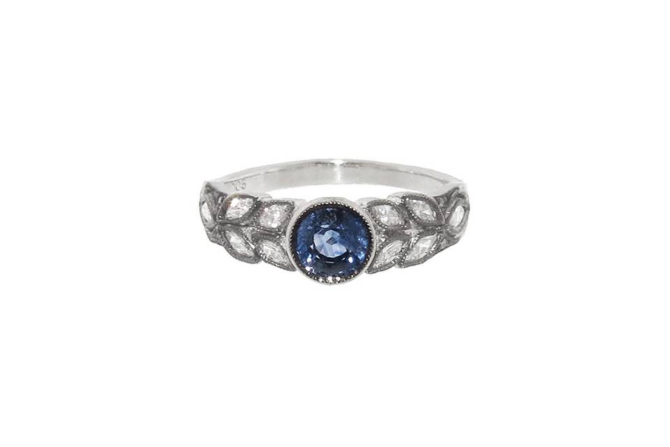 Simply stunning from Cathy Waterman, this round blue sapphire is set in platinum and has a carat weight of .83 carats. The band is composed of bright marquis diamond leaves, measuring 1/4