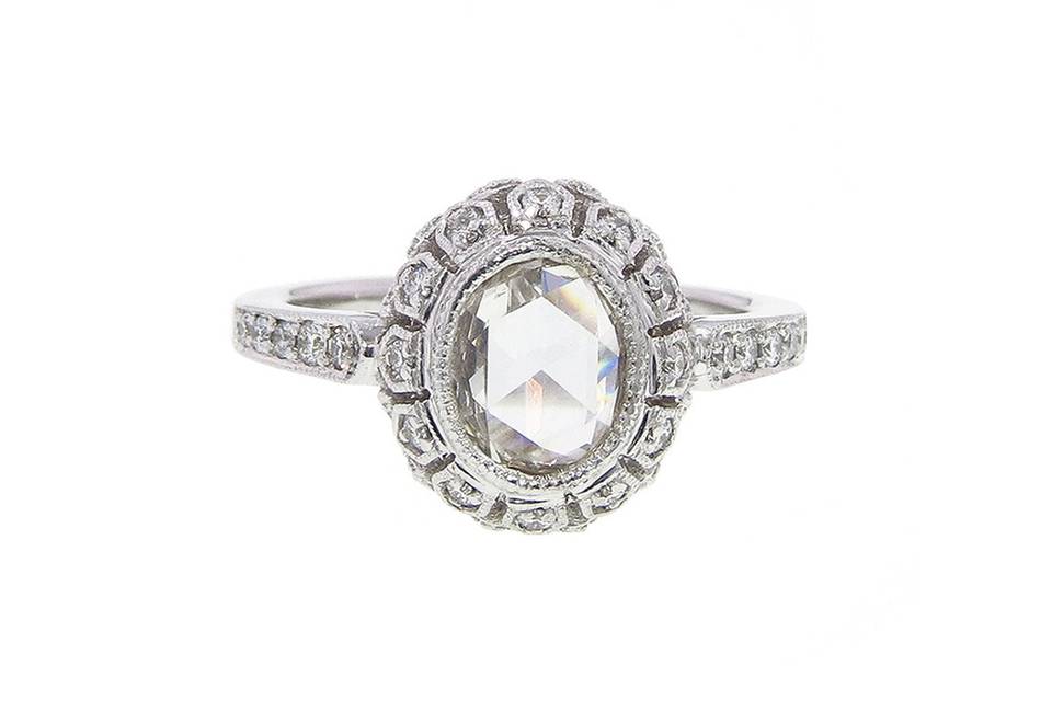 This handmade ring from jewelry designer Sethi Couture is composed of 18 karat white gold. An oval rose cut diamond center bezel is set in an antique styled setting with diamond detail and sits flush on a white gold band. <p>The center stone has a carat weight of.98 carats and the accent diamonds share a carat weight of .26 carats.