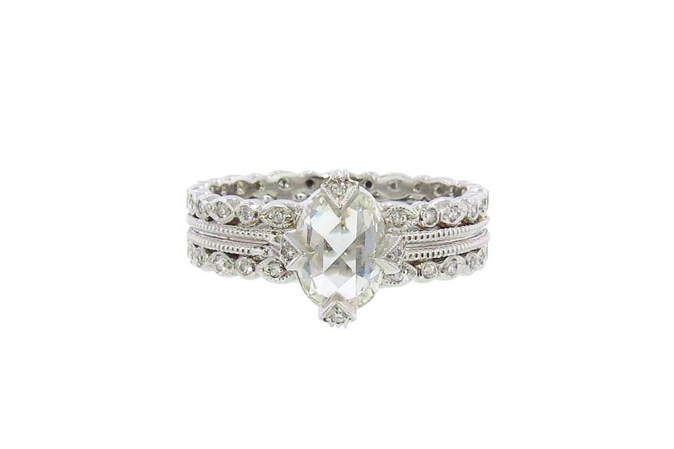 From jewelry designer Cathy Waterman in platinum and diamonds, this elegantly scalloped band with hand detailed milgraining has a stunning oval rose cut diamond center. The diamond is set in her signature thorn prong setting with tiny sparkling diamond accents and has a carat weight of 1.30 carats. The band measures 3/16